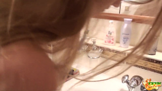 Великолепная блондинка расчесывала шикарные волосы в ванной комнате
